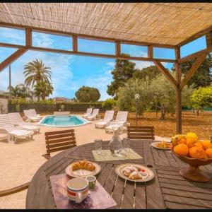 a wooden table with food on top of it with a pool at RESORT Valle del Re in Partinico