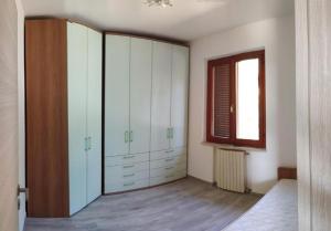 sypialnia z białymi szafkami i oknem w obiekcie VILLA OMBRA w mieście Casa Morcone