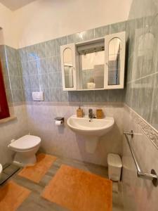 W łazience znajduje się umywalka, toaleta i lustro. w obiekcie VILLA OMBRA w mieście Casa Morcone