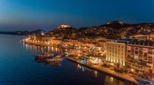 una città illuminata di notte con barche in acqua di Apartman Mediteran a Šibenik