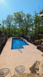 a swimming pool on a patio with two chairs at Le Riverain - Condo neuf au bord de l'eau in Shawinigan