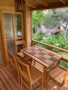einen Holztisch und Stühle auf der Veranda einer Hütte in der Unterkunft BUNGALOV in Kemer