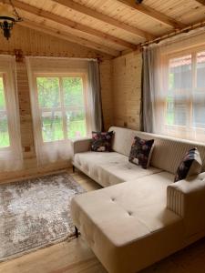 uma sala de estar com um sofá e duas janelas em BUNGALOV em Kemer
