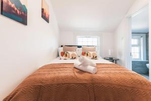 a white teddy bear sitting on top of a bed at Creedite - 2 Bedroom Flat in Reading