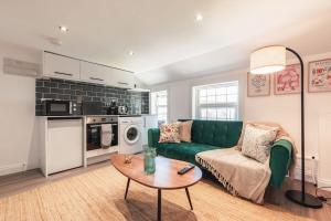 a living room with a green couch and a table at Creedite - 2 Bedroom Flat in Reading