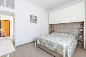 a bedroom with a bed in a white room at Sissi's Home [Due Passi Dal Mare, Free WiFi] in Punta Marina