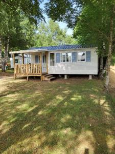 a tiny house with a porch and a deck at mobilhome 5 couchages in Nages