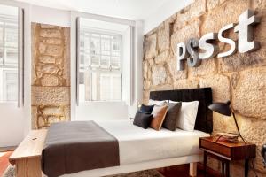 a bedroom with a bed and a brick wall at Oporto Chic & Cozy Studio Apartments in Porto