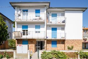 un condominio con porte blu e balconi di Sissi's Home [Due Passi Dal Mare, Free WiFi] a Punta Marina