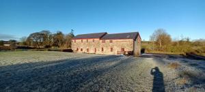 a shadow of a person standing in front of a brick building at The Old Mill, Kilcorkey, Bellanagare, Castlerea, County Roscommon - West of Ireland in Bellanagare