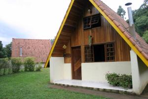 una casa con un techo grande con una puerta grande en Pousada Passaredo, en Gonçalves