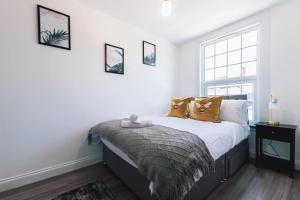 a bedroom with a bed with pillows and a window at Barite - 1 Bedroom Flat in Reading