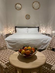 a bowl of fruit on a table in front of a bed at Riad Hanya in Marrakech