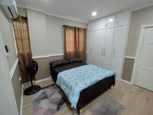 een slaapkamer met een bed in een kamer met witte kasten bij Chez Moi in Castries