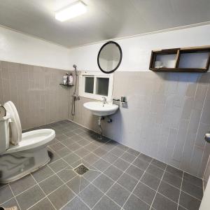 a bathroom with a toilet and a sink and a mirror at Yeobyeol Guesthouse in Jeonju