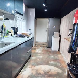 a kitchen with a refrigerator and a counter top at Yeobyeol Guesthouse in Jeonju