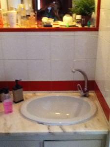 a bathroom with a sink with a faucet at Spacious, Sunny, Cozy & Secure in Mindelo