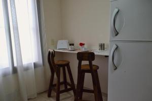 a kitchen with two bar stools and a refrigerator at Ideal Place in Godoy Cruz