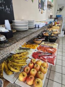 a buffet with bananas apples and other fruits and vegetables at Pousada Jasmine in João Pessoa