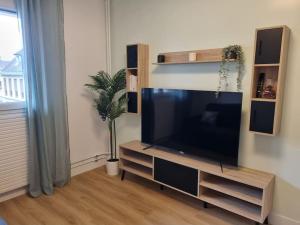 ein Wohnzimmer mit einem großen Flachbild-TV in der Unterkunft Appart Poissy, proche Paris / confortable et cosy in Poissy