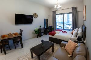 a living room with a bed and a dining room at Cosy Studio with Canal Views by Orion Short Stays - 521 Monthly Offer in Dubai