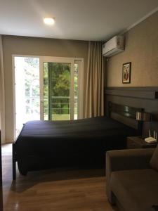 Un dormitorio con una cama grande y una ventana en Departamentos Casa del Parque en Necochea