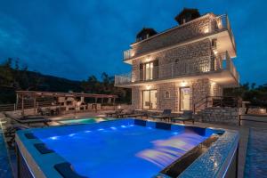 a villa with a swimming pool in front of a house at Villa Foteini in Skinária