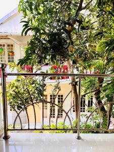 a fence with a tree in front of a building at Benheal Homestay in Cochin +57 photos