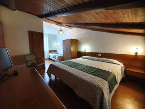 a hotel room with a bed and a desk and a television at Altavilla Albergo meublé in Tirano