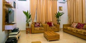 a living room with two couches and a tv at KUNN Apartments in Asaba