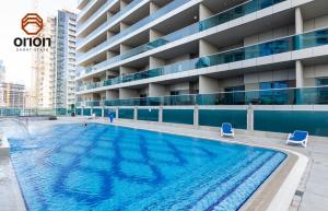 a large swimming pool in front of a building at Cosy Studio with Canal Views by Orion Short Stays - 521 Monthly Offer in Dubai