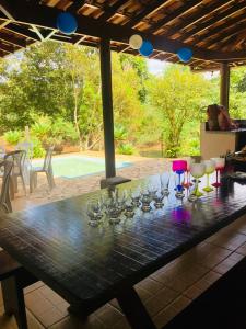 a large wooden table with wine glasses on it at Sítio Recanto do Paturi in Piranguinho