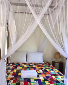 a bedroom with a bed with a canopy at Chalés do Maestro in Ilha de Boipeba