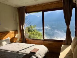 a bedroom with a bed and a large window at Fansipan Terrace Cafe and Homestay in Sa Pa