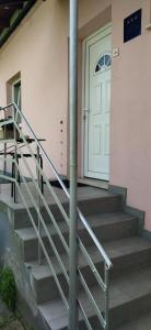 a set of stairs leading to a white door at Studio apartman Dolenac in Zagreb