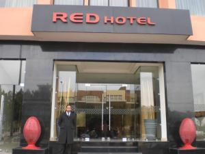 a man in a suit standing outside of a red hotel at Red Hotel Marrakech in Marrakesh