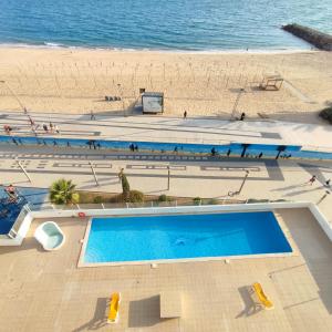 an overhead view of a swimming pool next to a beach at Ocean Blue II in Quarteira