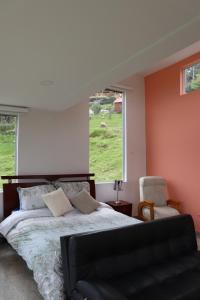 a bedroom with a bed and a chair and a window at Glamping en Granja Campo Hermoso in Cogua