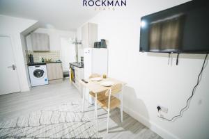 a kitchen with a small table and a refrigerator at 12D Alexandra Street - Charming Apartment in Central Southend Location by Rockman Stays in Southend-on-Sea
