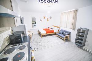 una cucina con divano e un letto in una camera di 12D Alexandra Street - Charming Apartment in Central Southend Location by Rockman Stays a Southend-on-Sea