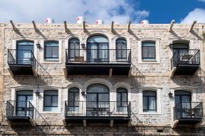 海法Vintage的一座古老的砖砌建筑,设有阳台和窗户。