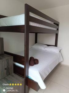 a bunk bed with a hat on top of it at Departamento moderno con jacuzzi privado - Porto Vitoria in Tonsupa