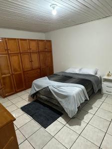 a bedroom with a bed and a tiled floor at Casa Recanto Alegria in Urubici