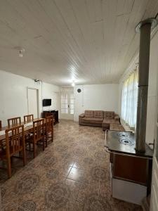 Casa Recanto Alegria في أوروبيسي: غرفة معيشة مع أريكة وطاولة وكراسي