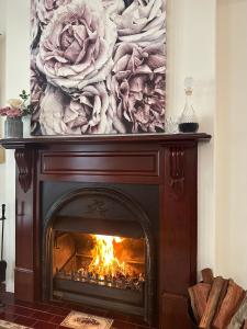 a fireplace in a living room with a painting above it at Wine and Roses Bed and Breakfast in McLaren Vale