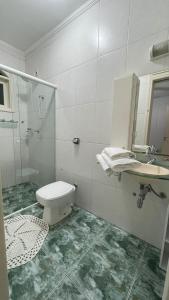 a bathroom with a toilet and a sink and a shower at Casa de Férias em Atibaia Piscina Climatizada in Atibaia