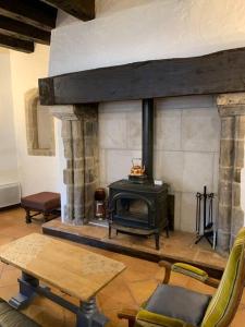 - un salon avec une cheminée et une cuisinière dans l'établissement Maison du Roy/ Upper Cambers, à Saint-Antonin