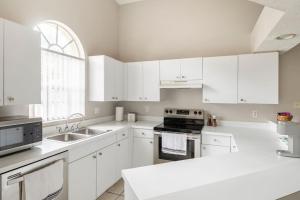 eine weiße Küche mit weißen Schränken und einem Waschbecken in der Unterkunft Quiet Getaway to Tampa & Orlando in Mulberry