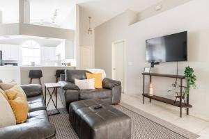 a living room with couches and a flat screen tv at Quiet Getaway to Tampa & Orlando in Mulberry
