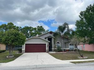 ein Haus mit einer roten Garage in einer Einfahrt in der Unterkunft Quiet Getaway to Tampa & Orlando in Mulberry